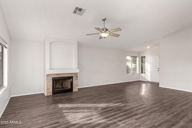 unfurnished living room featuring ceiling fan, dark hardwood / wood-style flooring, lofted ceiling, and a tile fireplace