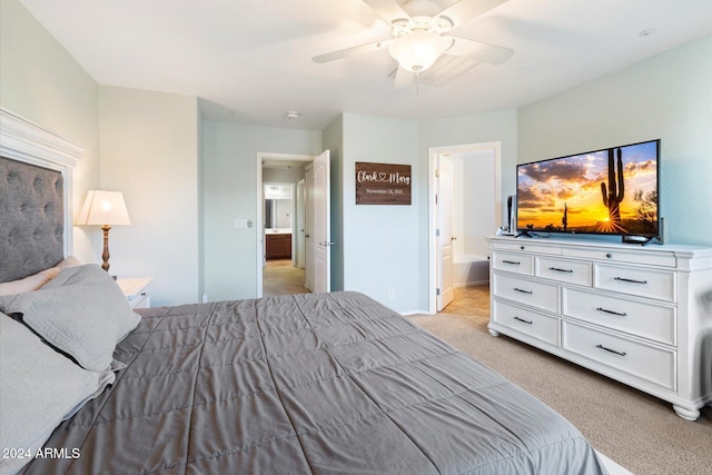 carpeted bedroom with ensuite bath and ceiling fan