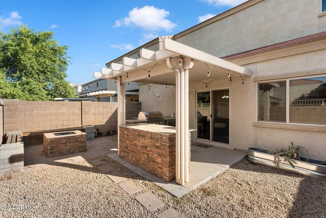 view of patio / terrace with an outdoor kitchen, a grill, and an outdoor fire pit