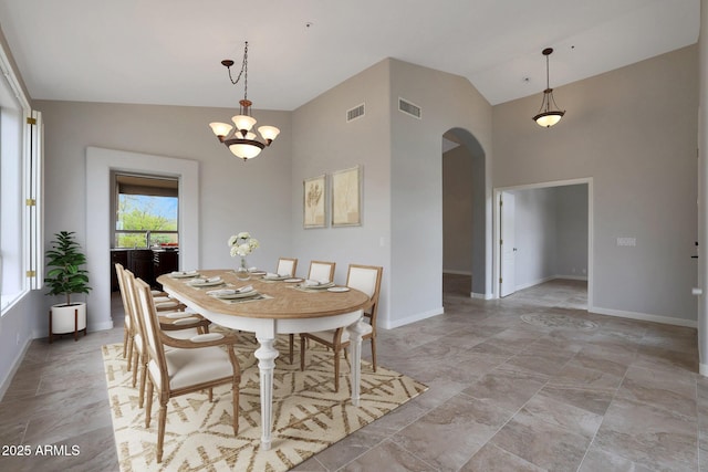 dining area with arched walkways, a notable chandelier, visible vents, and baseboards