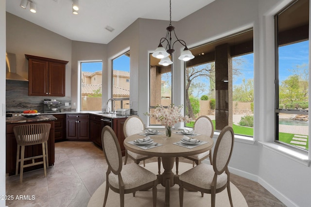 dining area featuring a chandelier, vaulted ceiling, plenty of natural light, and visible vents