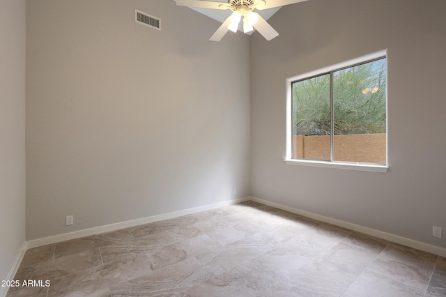 spare room featuring baseboards, a ceiling fan, and visible vents