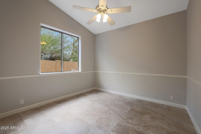 spare room featuring lofted ceiling, baseboards, and ceiling fan
