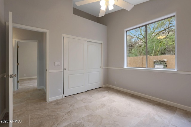 unfurnished bedroom with baseboards, a closet, and ceiling fan