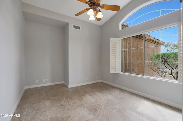 spare room with ceiling fan, vaulted ceiling, visible vents, and baseboards