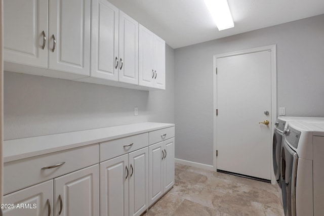 laundry room featuring cabinet space, baseboards, and separate washer and dryer