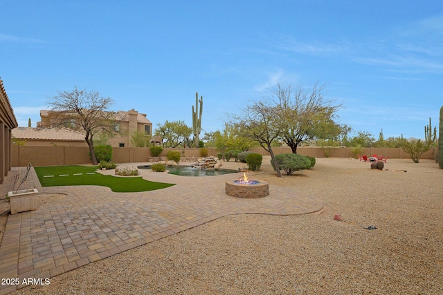 view of yard featuring a fenced backyard, a fire pit, and a patio