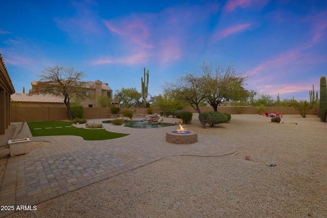 view of yard featuring a fire pit, a fenced backyard, and a patio