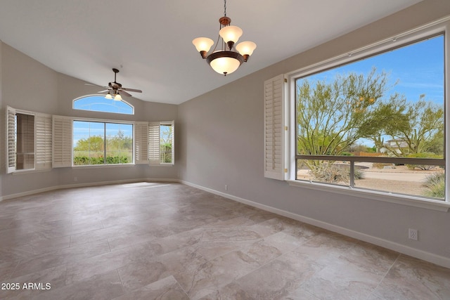 spare room featuring lofted ceiling, baseboards, and ceiling fan with notable chandelier