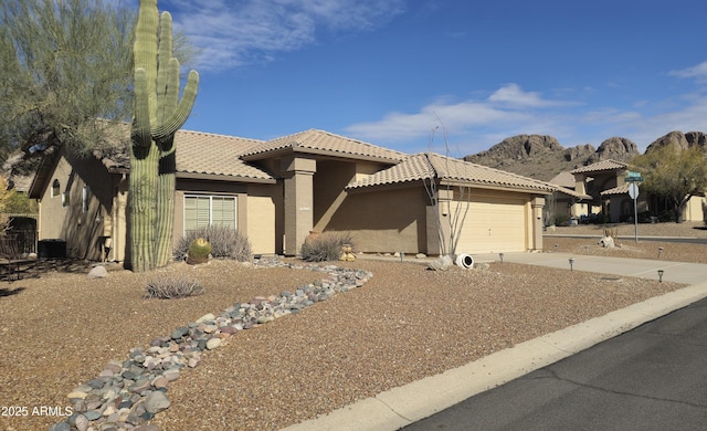 view of front of home with a garage and a mountain view