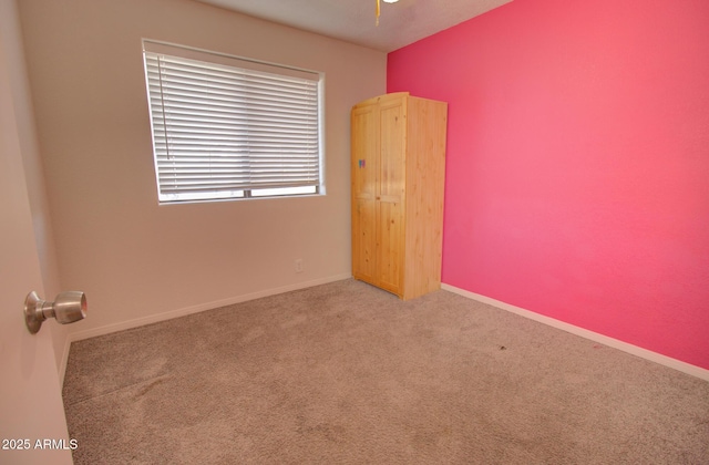 empty room with carpet and baseboards