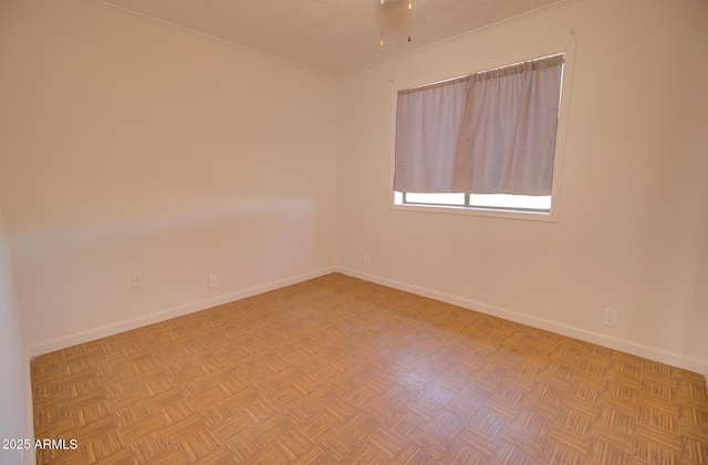 spare room with baseboards and ornamental molding