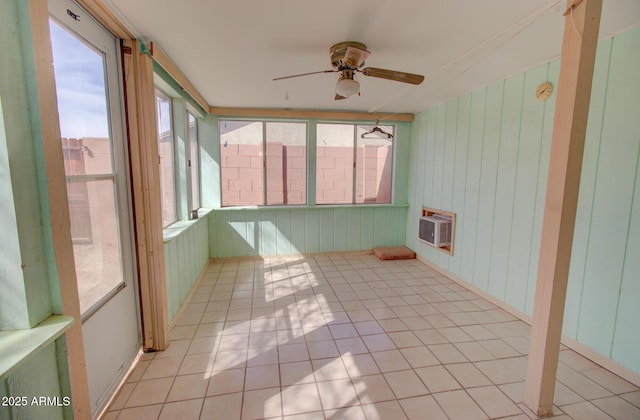 unfurnished sunroom with ceiling fan and a wall mounted AC