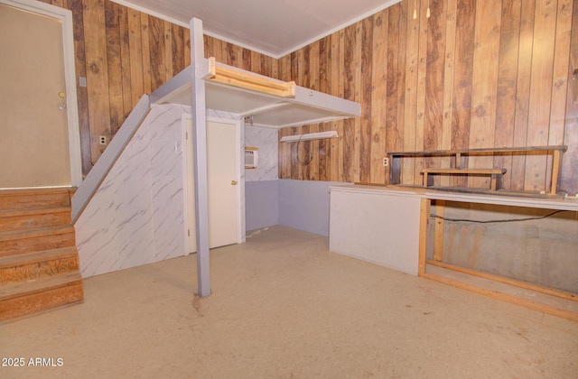 interior space with crown molding, wood walls, and stairway