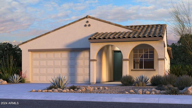 mediterranean / spanish-style house with stucco siding, driveway, and a tile roof