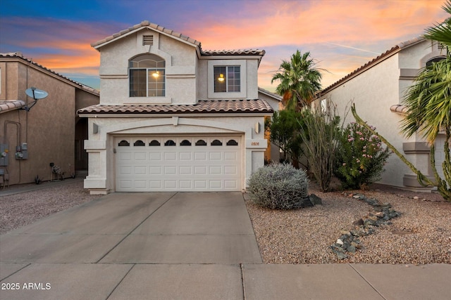 mediterranean / spanish-style house with stucco siding, concrete driveway, an attached garage, and a tile roof