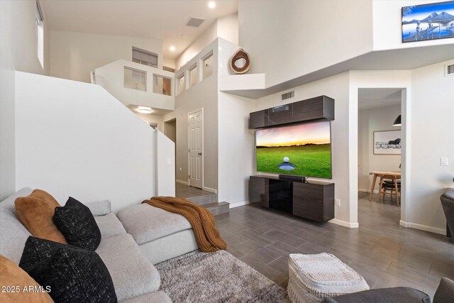 living area with a high ceiling, baseboards, dark wood finished floors, and recessed lighting