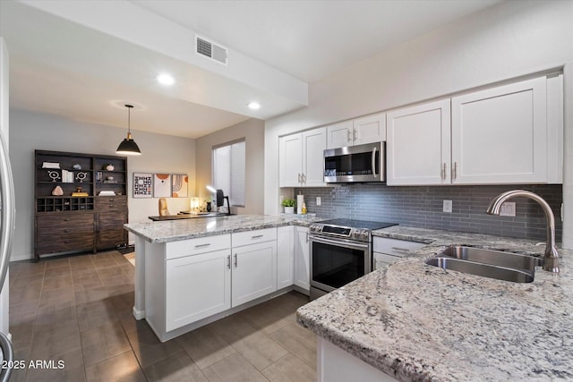 kitchen with appliances with stainless steel finishes, a sink, a peninsula, tasteful backsplash, and white cabinets