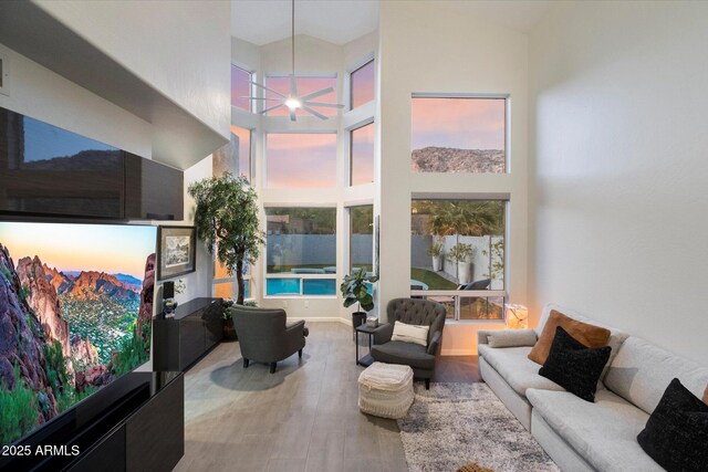 living room with a high ceiling and wood finished floors