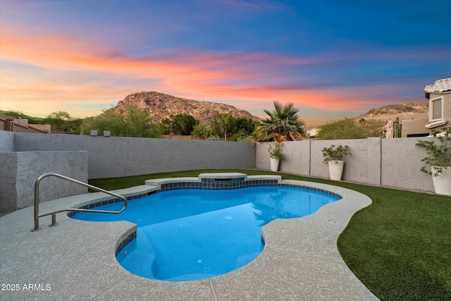 pool at dusk with a fenced backyard and a mountain view
