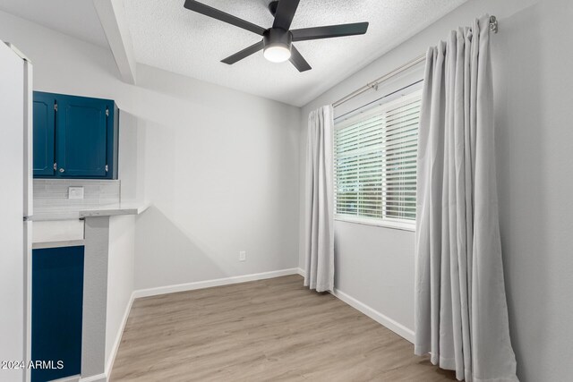 455 S Delaware Dr Unit 120, Apache Junction, AZ 85120 - unfurnished dining area featuring a textured ceiling, a ceiling fan, light wood finished floors, and baseboards