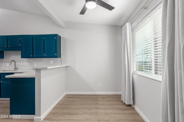 455 S Delaware Dr Unit 120, Apache Junction, AZ 85120 - kitchen featuring blue cabinets, a sink, backsplash, ceiling fan, and light wood finished floors