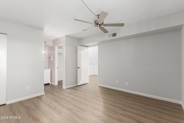 455 S Delaware Dr Unit 120, Apache Junction, AZ 85120 - unfurnished bedroom with wood finished floors, a textured ceiling, baseboards, a ceiling fan, and a spacious closet