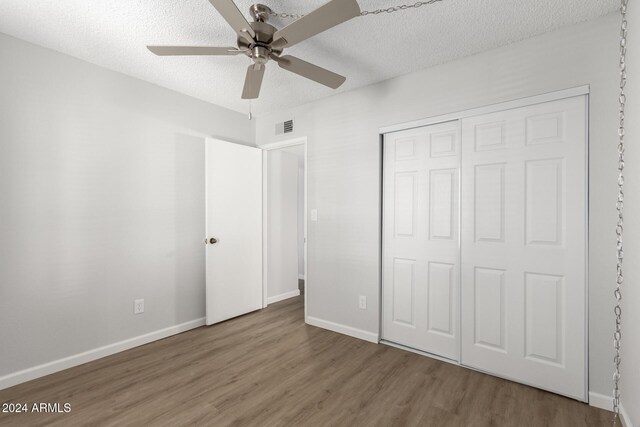 455 S Delaware Dr Unit 120, Apache Junction, AZ 85120 - unfurnished bedroom featuring wood finished floors, a textured ceiling, a closet, baseboards, and a ceiling fan