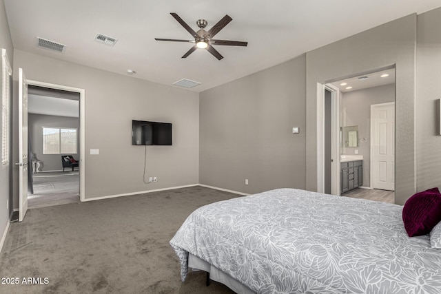 carpeted bedroom with ensuite bath and ceiling fan