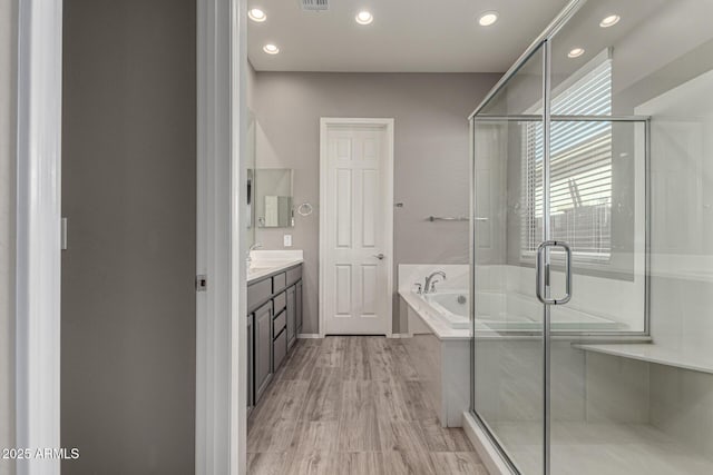 bathroom with independent shower and bath, vanity, and hardwood / wood-style flooring