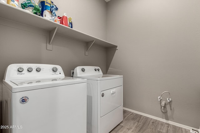 clothes washing area with independent washer and dryer and light wood-type flooring