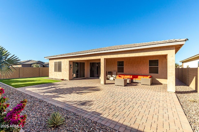 back of property with a patio and an outdoor living space