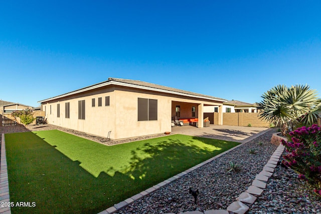 rear view of property featuring a patio and a lawn