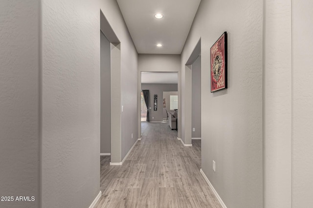 hallway with light hardwood / wood-style floors