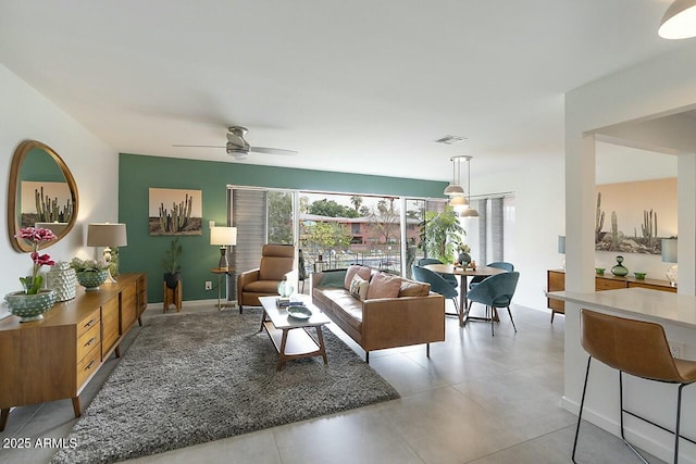 living area with ceiling fan, visible vents, and baseboards