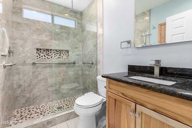 full bathroom featuring toilet, a tile shower, and vanity