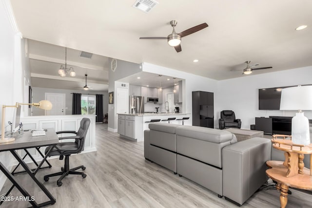 living area with a ceiling fan, light wood finished floors, and recessed lighting