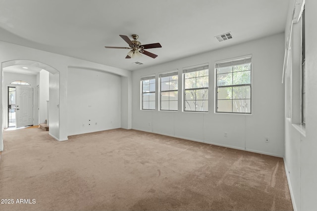 carpeted spare room featuring ceiling fan