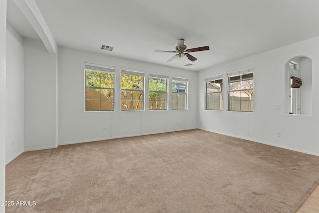 empty room featuring ceiling fan and light carpet