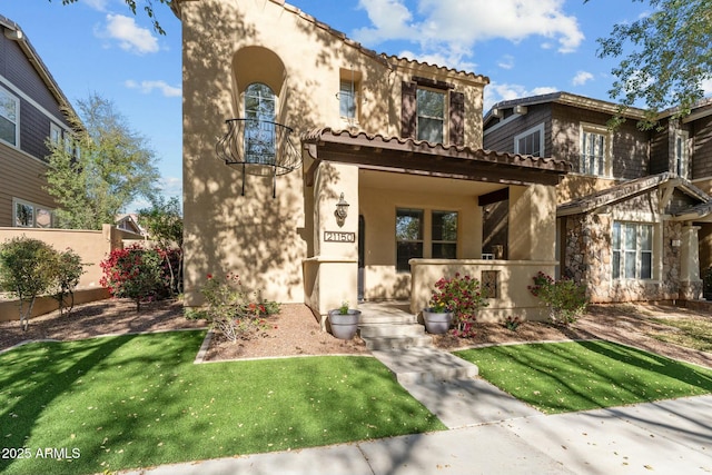 mediterranean / spanish-style home with a front yard and a porch