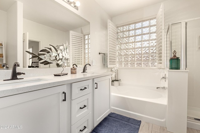 bathroom with independent shower and bath, vanity, and wood-type flooring