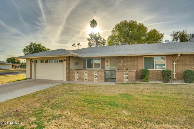 ranch-style home featuring a lawn, a garage, and covered porch