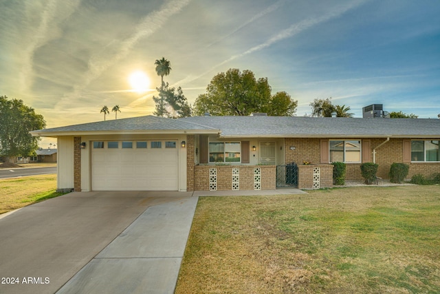 single story home featuring a yard and a garage