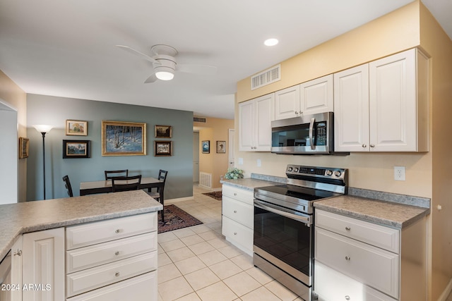 kitchen featuring stainless steel appliances, white cabinetry, ceiling fan, and light tile patterned flooring