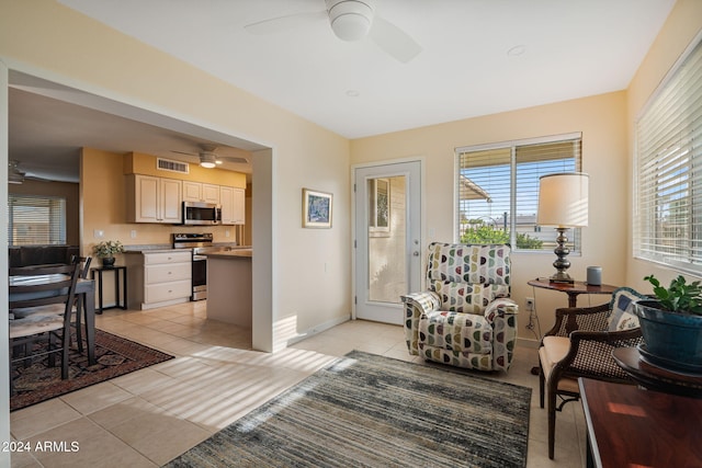 tiled living room with plenty of natural light and ceiling fan