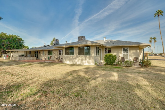 back of house with a yard and a patio