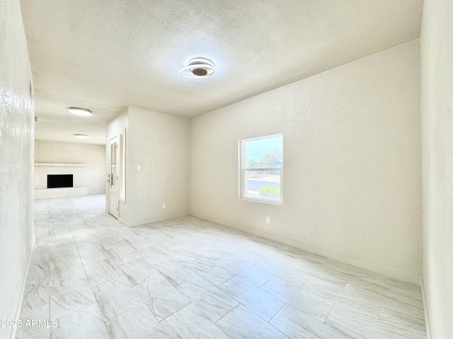 empty room featuring a fireplace and a textured ceiling