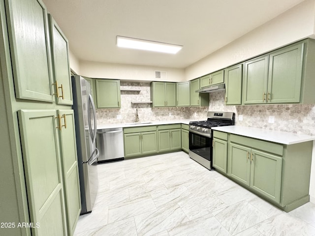 kitchen featuring under cabinet range hood, stainless steel appliances, green cabinets, and a sink