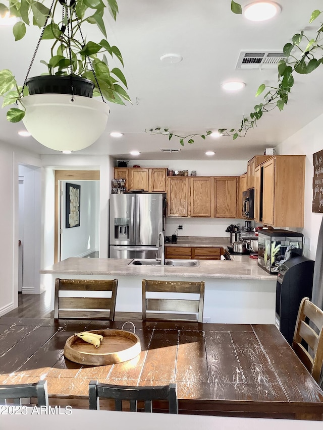 kitchen featuring stainless steel appliances, kitchen peninsula, and sink