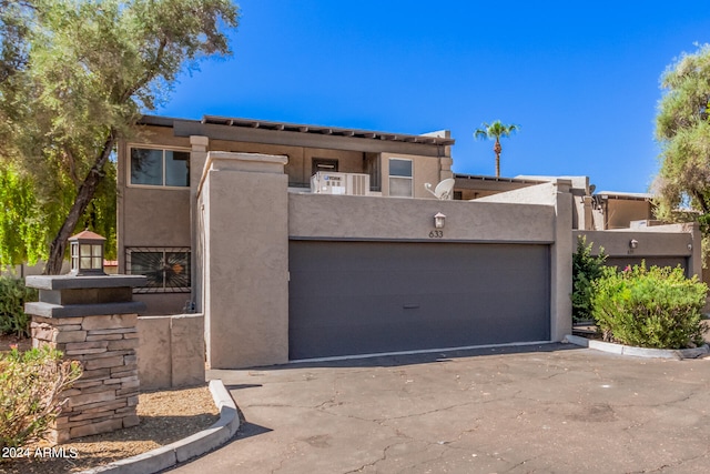 pueblo revival-style home featuring a garage